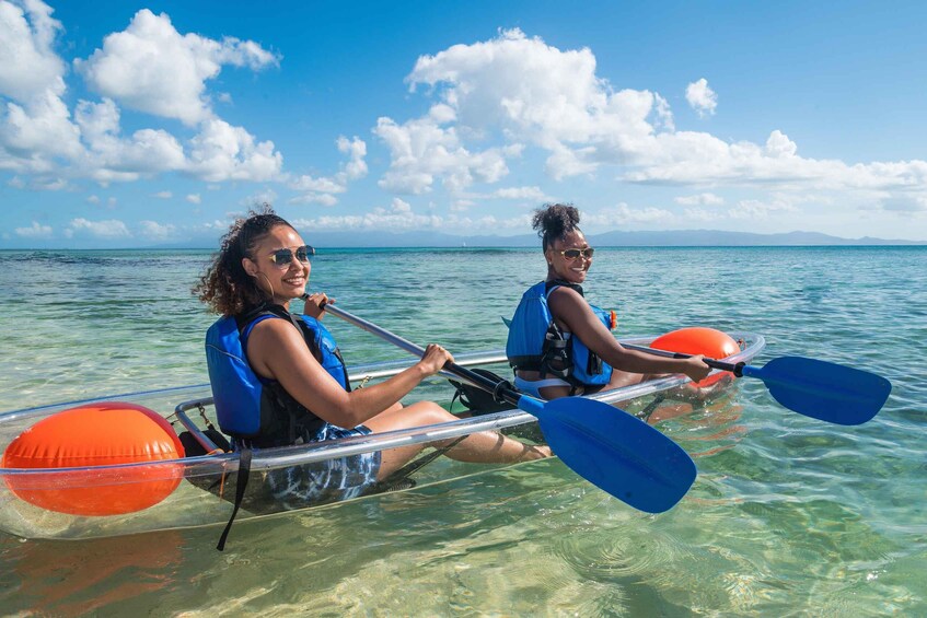 Two people kayaking on a calm sea with clear skies. 1