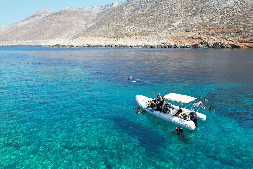 A clear blue sea with a boat carrying scuba divers. 3