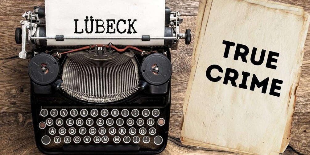A vintage typewriter with a sheet of paper that reads 'TRUE CRIME' next to it. 1