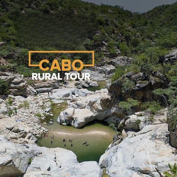 A rural landscape with a rocky terrain, a small water body, and greenery. 5