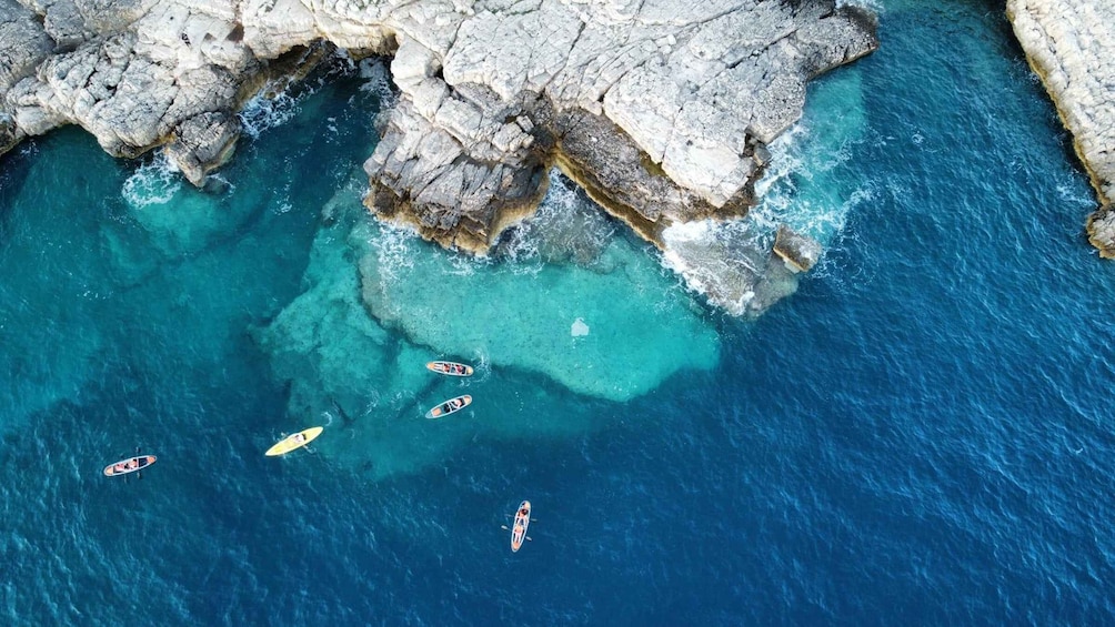 A coastal area with rocky cliffs and clear turquoise waters. 3