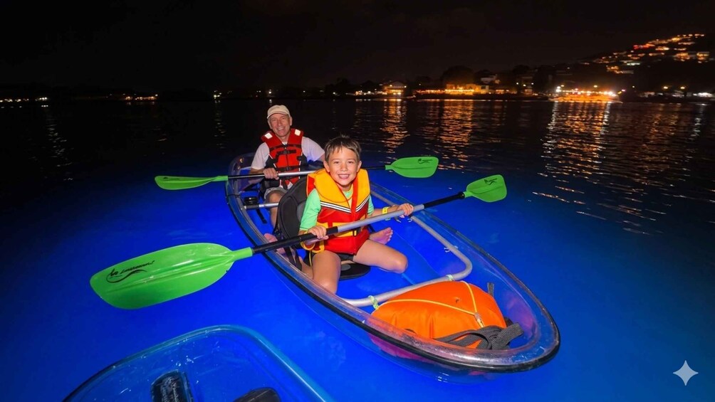 Two people in a kayak on a body of water at night with city lights in the background. 4