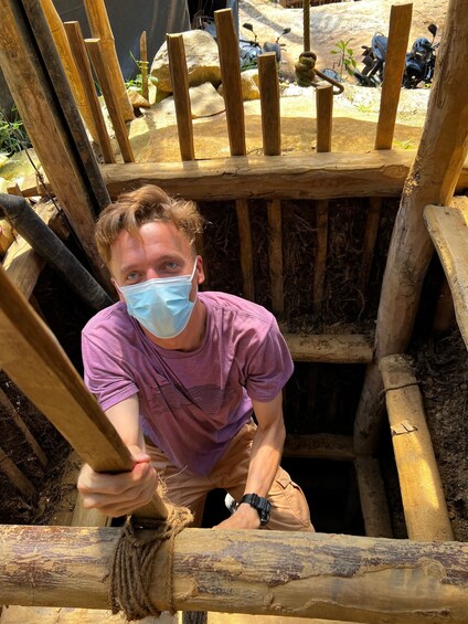 A person climbing a wooden structure with ropes. 5