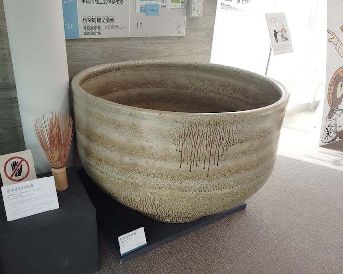 A large ceramic bowl on display with a sign indicating it is not to be touched. 1
