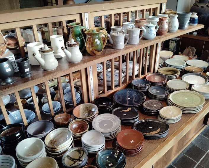 A variety of ceramic dishes and pottery displayed on shelves. 4