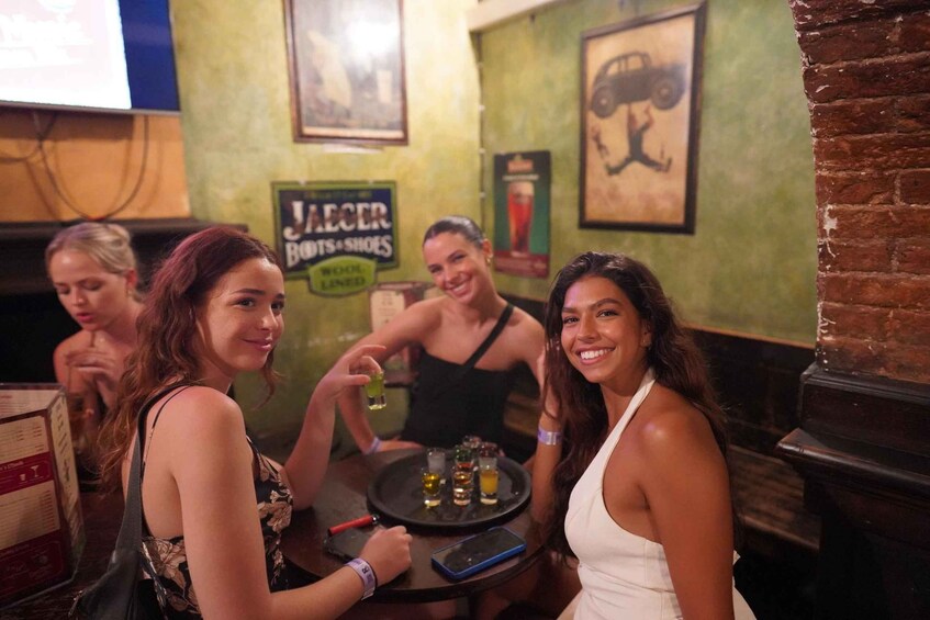 A group of people sitting at a bar with a sign for 'JELCER BOOTS & SHOES' and a vehicle illustration on the wall. 5