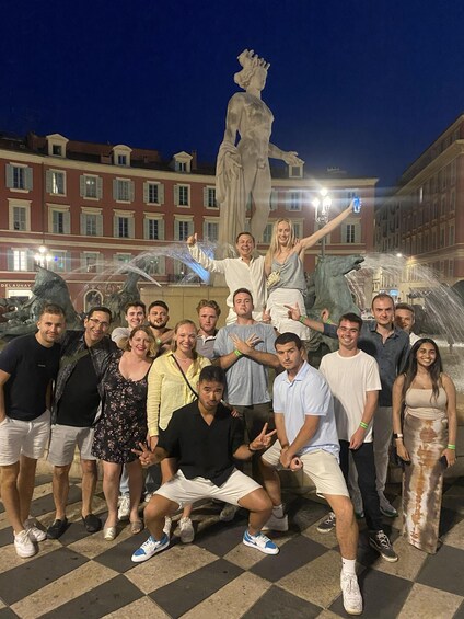 A group of people posing in front of a fountain with a statue in the background. 3