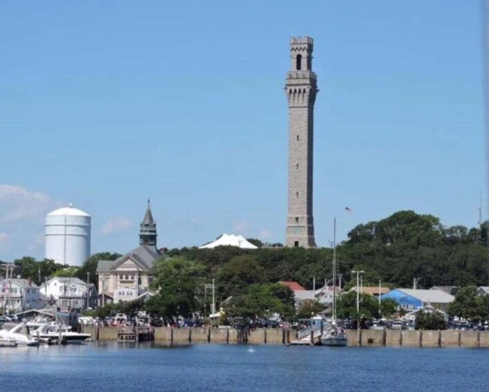 A coastal town with a prominent tower, a water tower, and a church. 1