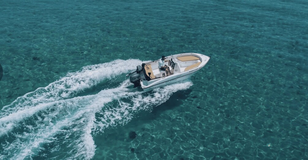 A speedboat moving through clear turquoise water. 4