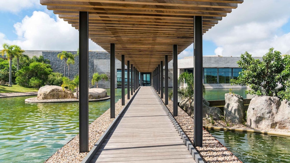 A wooden walkway over water, surrounded by rocks and greenery. 4