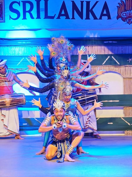 A stage with performers in elaborate costumes, a sign reading 'SRILANKA', and a backdrop with cultural designs. 1