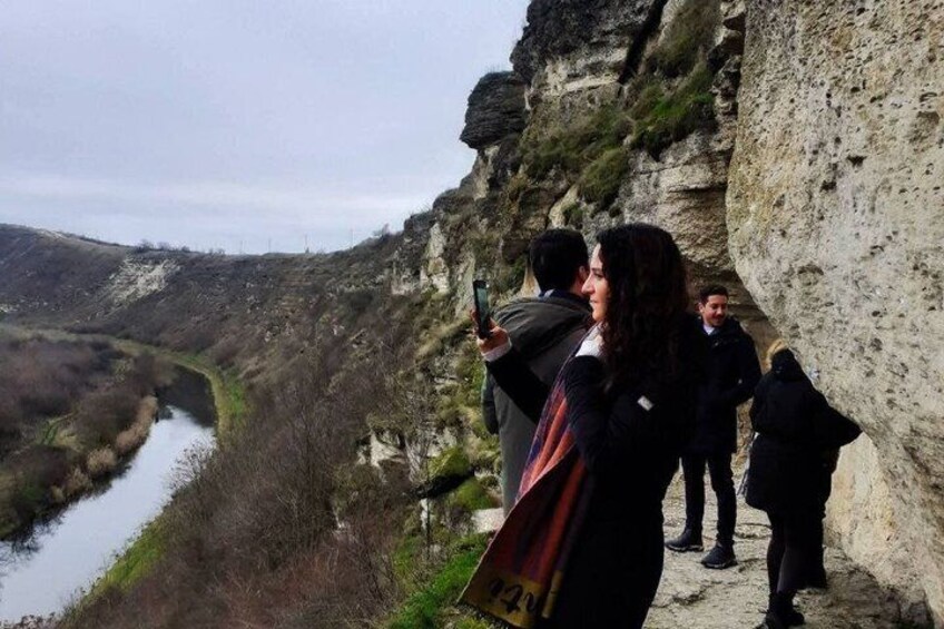 A group of people standing on a rocky cliff overlooking a river. 2