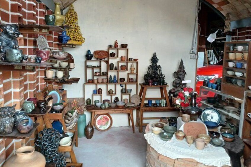 A pottery shop with shelves of ceramic items and a display of pottery. 3