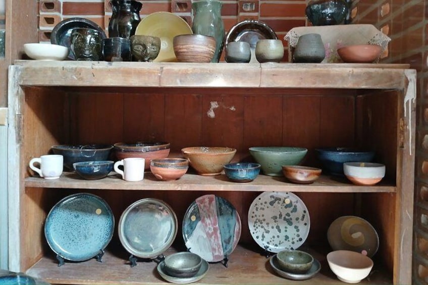 A wooden shelf displaying various ceramic bowls and plates. 5