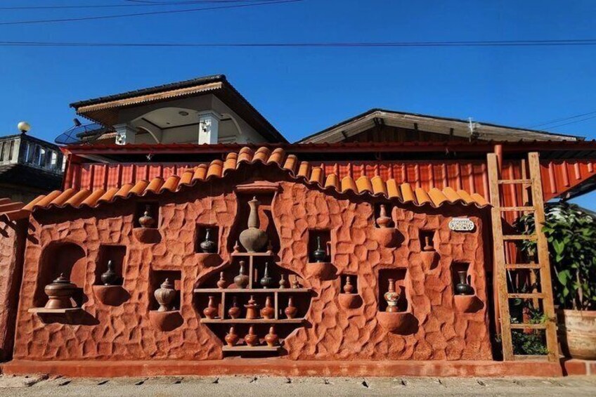 A building with a red facade, multiple windows, and a tiled roof. 2