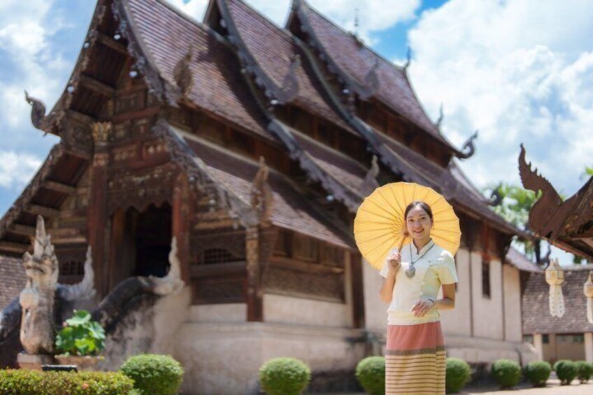 A traditional wooden building with a peaked roof, surrounded by well-maintained greenery. 1