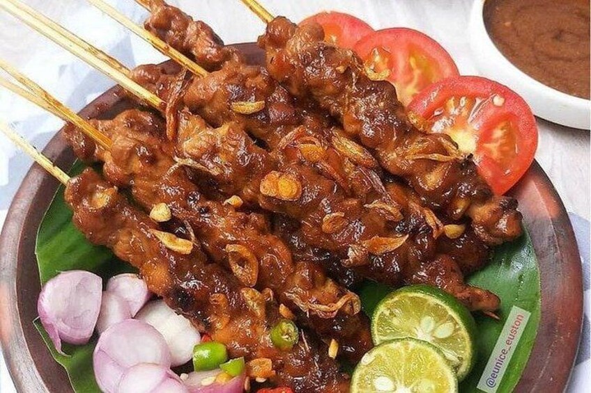 Skewered meat garnished with sliced onions, tomatoes, and lime. 3