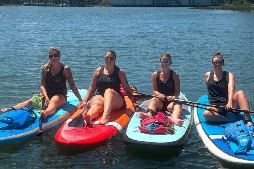 Four people on paddleboards in a calm body of water. 4