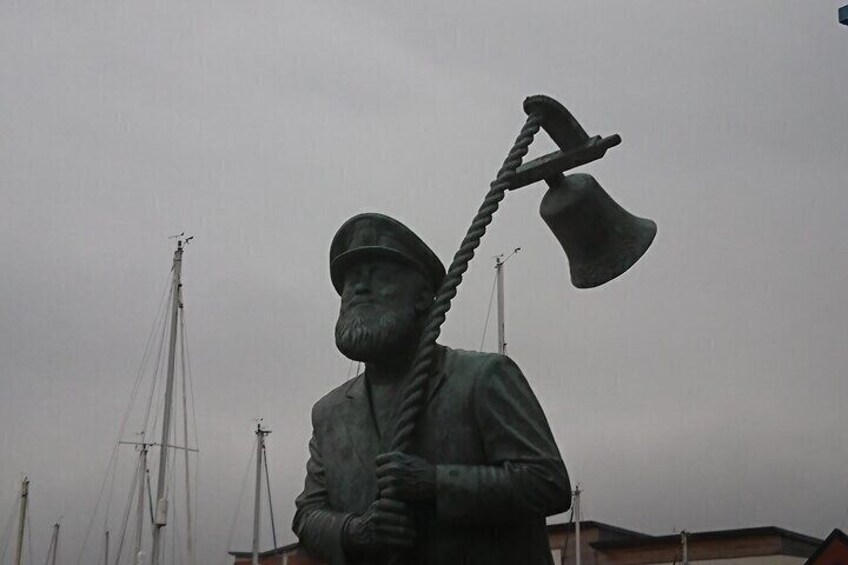 A statue of a bearded man holding a rope and an axe. 4