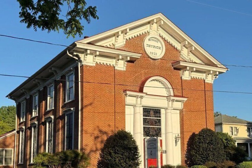 A brick building with a white pediment and a sign that reads 'Metropolitan Church 1873'. 4