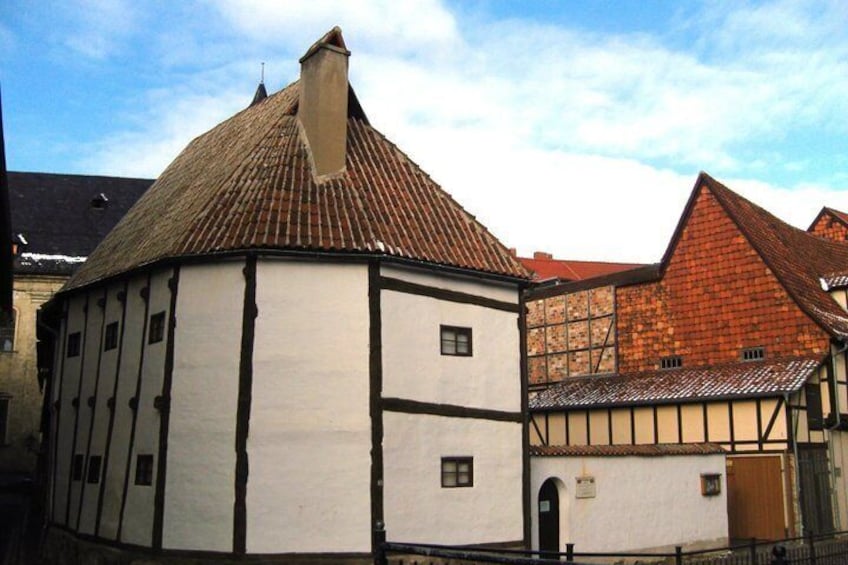 A traditional half-timbered building with a tiled roof and white walls. 5