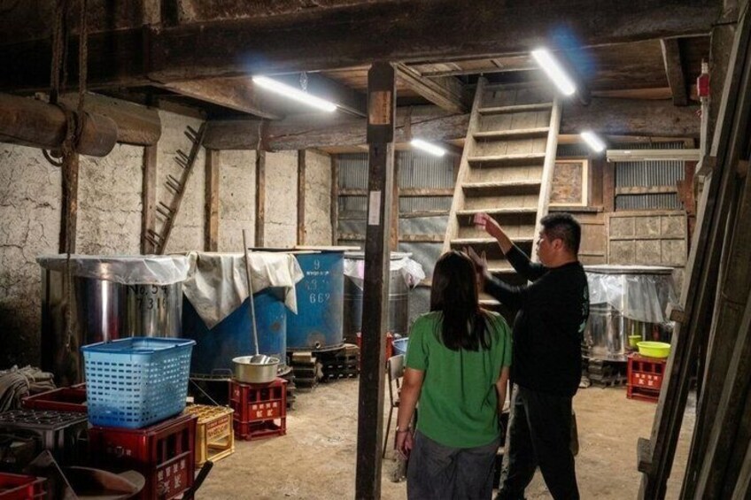 A rustic interior with wooden beams, metal containers, and a ladder. 3