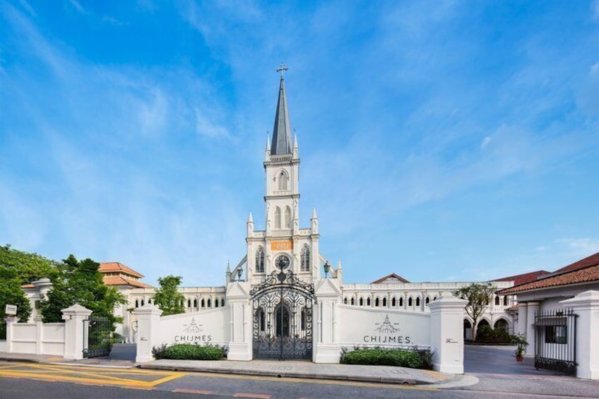 A church with a tall steeple, a gate labeled 'CHIJMES,' and a clear blue sky. 3