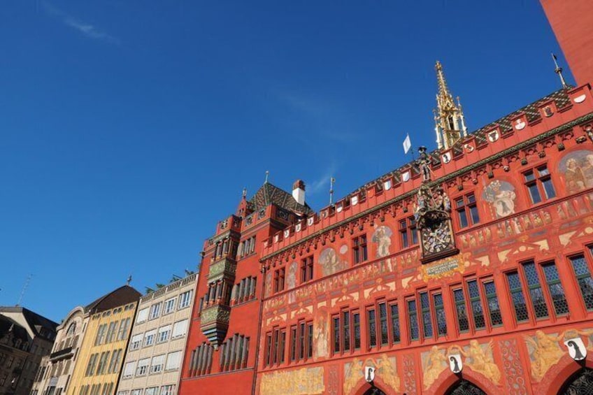 A red building with ornate decorations and a clock. 1