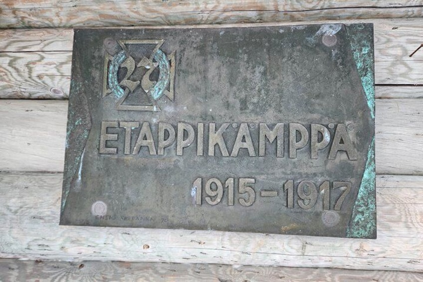 A weathered metal plaque with the inscription 'ETAPPIKAMPPA 1915-1917' mounted on a wooden surface. 5