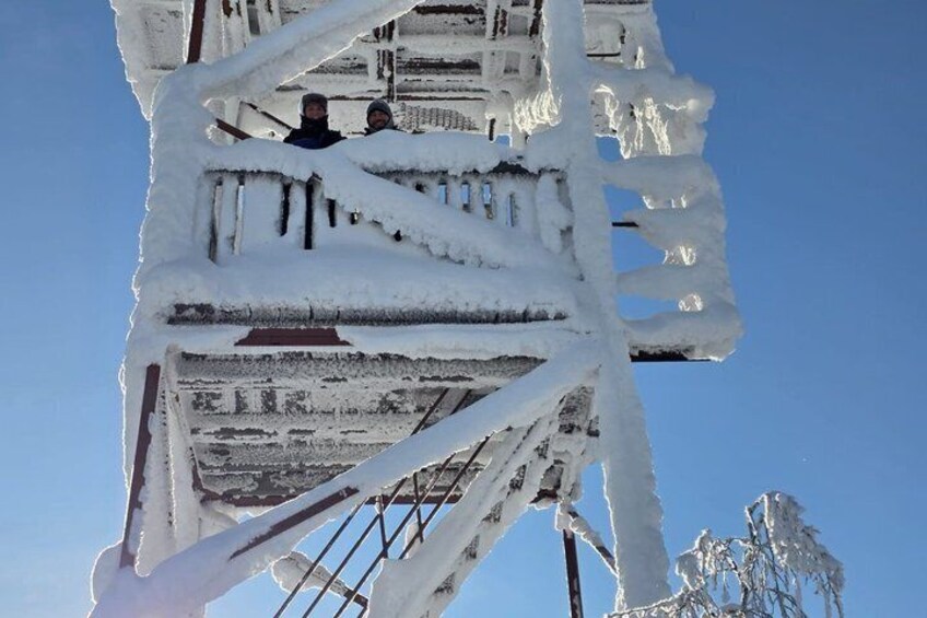 A snow-covered structure with icicles and a clear blue sky. 3