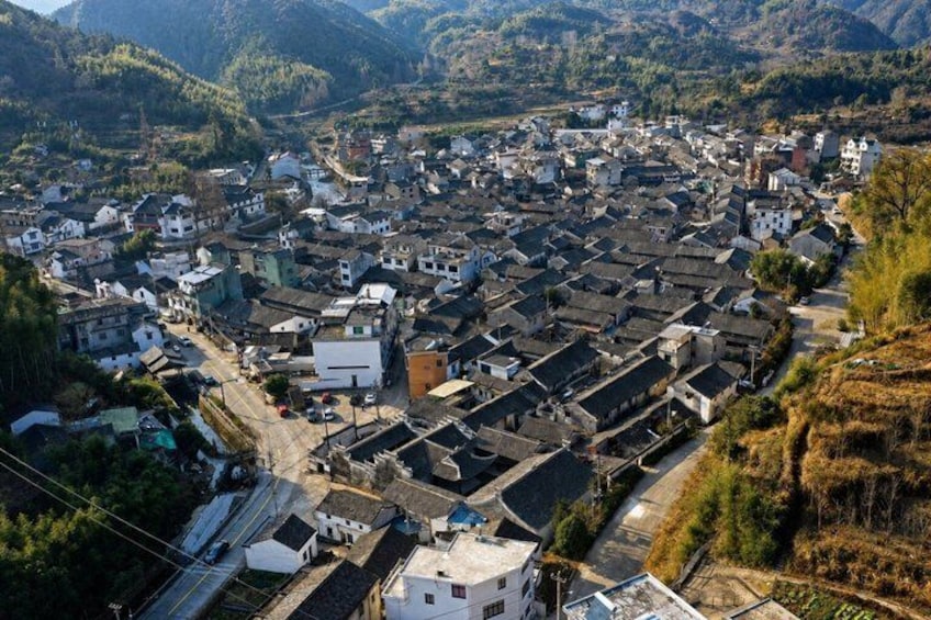 A mountainous village with traditional houses and a winding road. 4