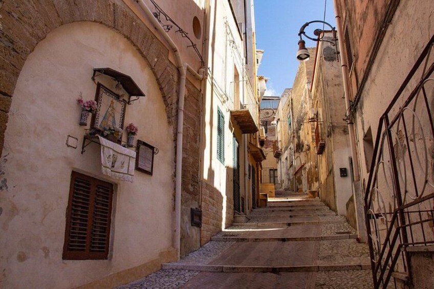 A narrow street with stone steps, arched doorways, and traditional architecture. 2