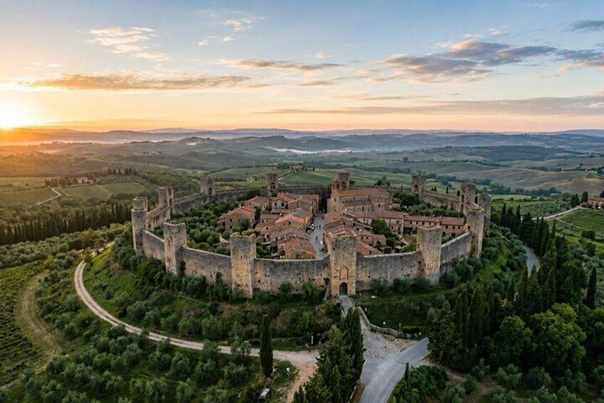 A medieval castle surrounded by lush greenery and rolling hills. 1