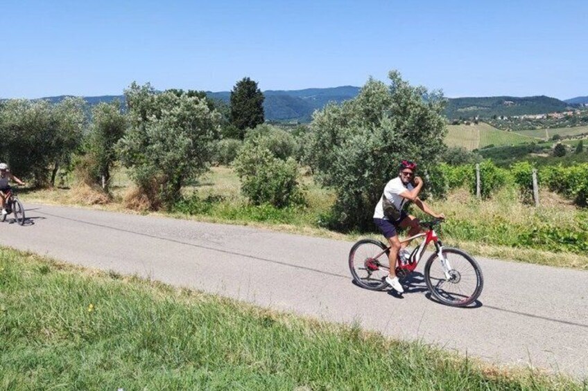 A cyclist on a paved path with a rural landscape in the background. 5