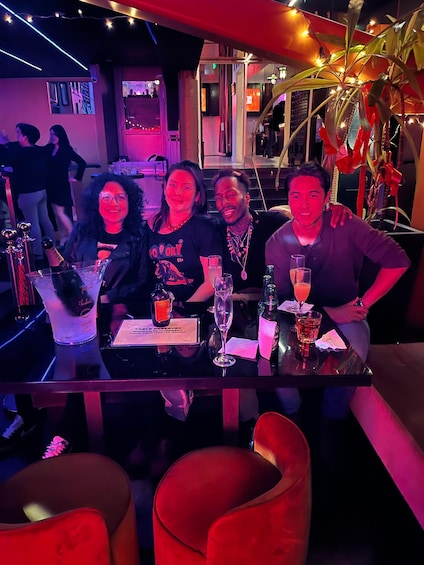 A group of people seated at a bar with drinks and a sign indicating a reserved table. 3