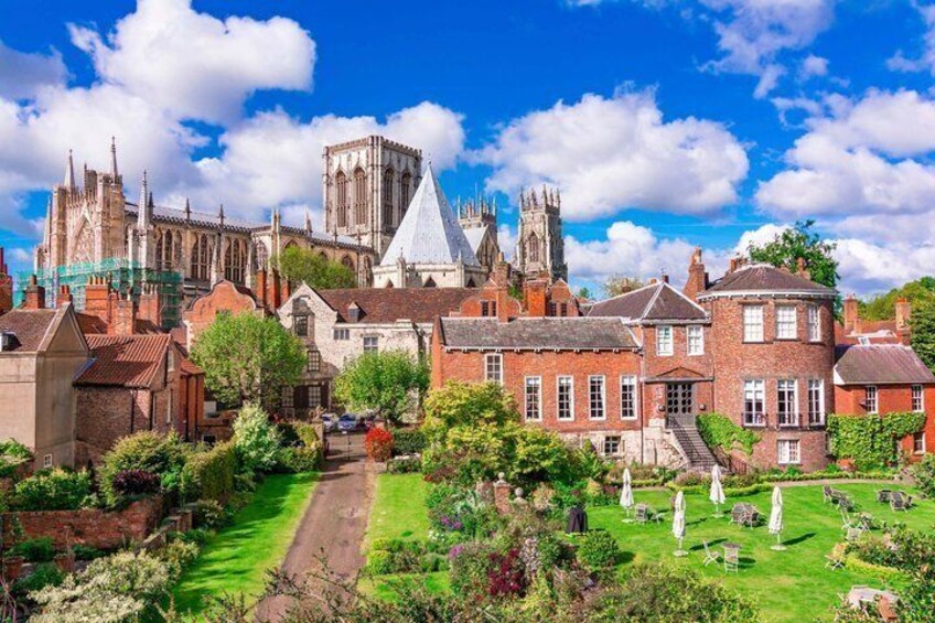 A historic town with a prominent cathedral, lush gardens, and traditional architecture. 1