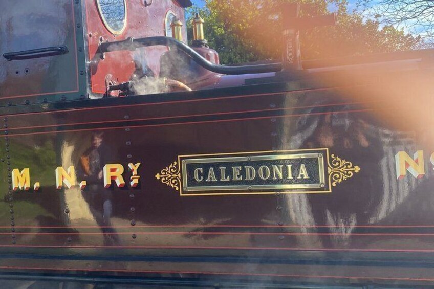 A steam locomotive with the name 'CALEDONIA' and the letters 'M.N.R.Y' on its side. 3