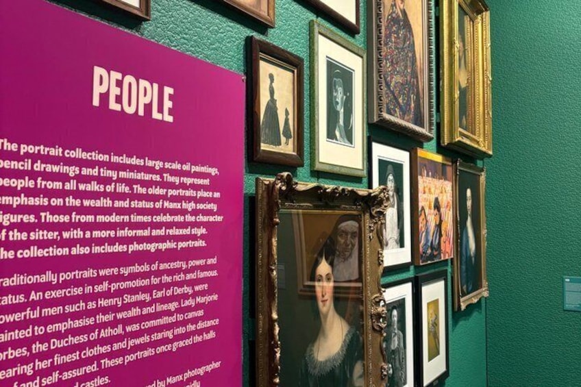 A gallery wall with framed portraits and a pink informational panel titled 'PEOPLE'. 5