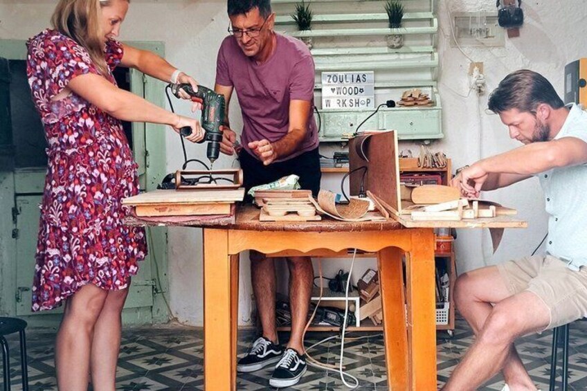 A workshop with a table, tools, and a sign that reads 'ZOUILAS WOOD & RCK SHOP'. 1