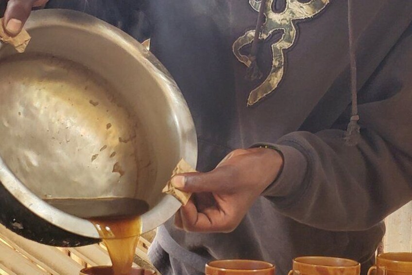 A person pouring liquid from a bowl into a cup. 5