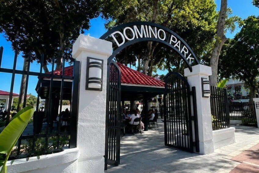 A gated entrance to Domino Park with a red roof structure and a clear blue sky. 2