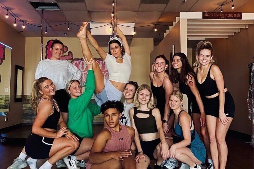 A group of people in a dance studio with mirrors and a sign that reads 'Always take the scenic route.' 2