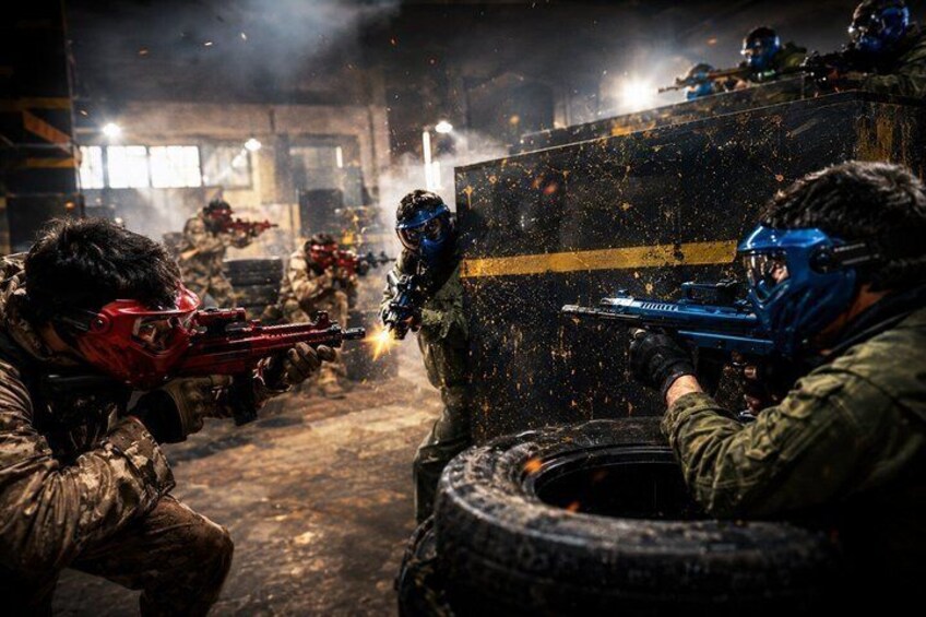 A paintball game in an industrial setting with players in camouflage and protective gear. 1