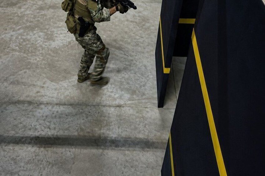 A person in military attire running on a concrete floor. 3