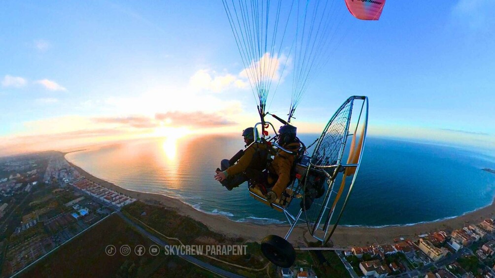 A paragliding scene with a coastal landscape and a sunset. 1