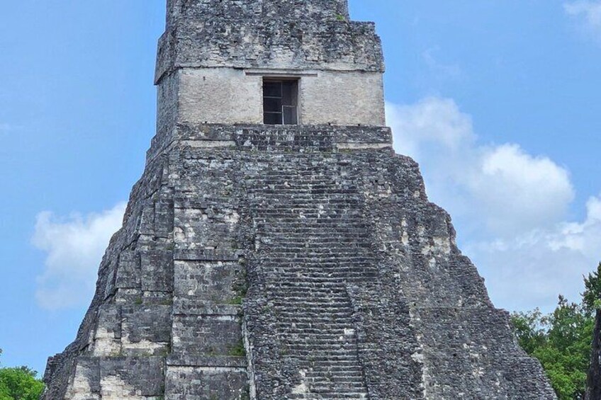 A tall, ancient stone structure with a small window at the top. 2