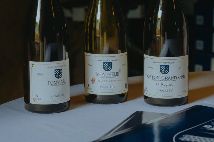 Three wine bottles with labels on a table. 4