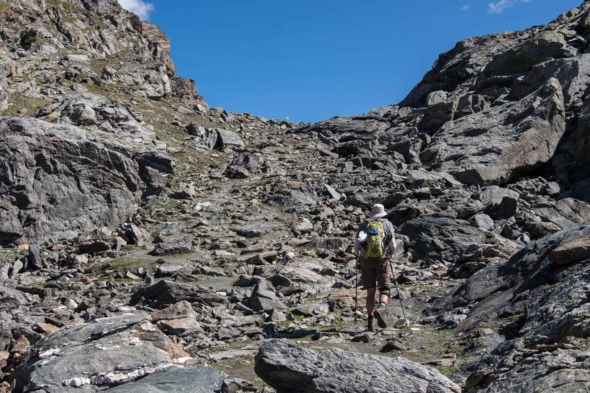 A hiker navigating a rocky mountain trail. 3