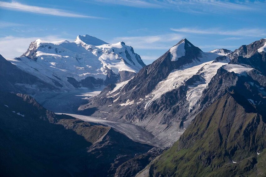 A mountainous landscape with snow-covered peaks and a glacier. 2