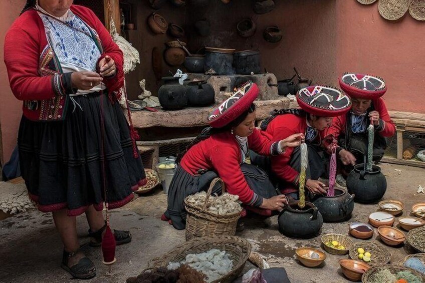A traditional market scene with people in red attire, cooking outdoors with pots and baskets. 1